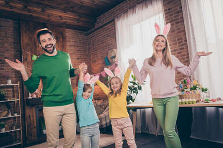 Photo of full positive funky family hold hands have good mood festive event house indoors