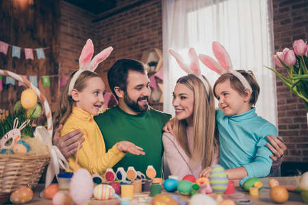 Portrait of attractive funny cheerful family wife husband coloring eggs creative art hugging...