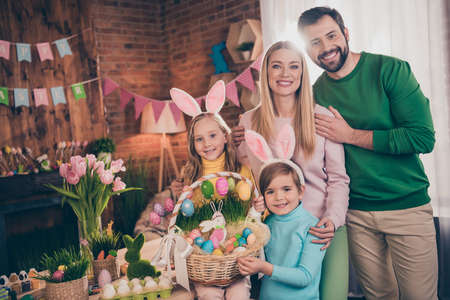 Photo of full friendly family hold easter basket embrace wear bunny ears house indoors