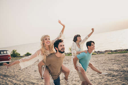 Photo of young impressed two girlfriend boyfriend piggyback go on shore sand exotic holiday trip wear trend cloth outdoorsの写真素材