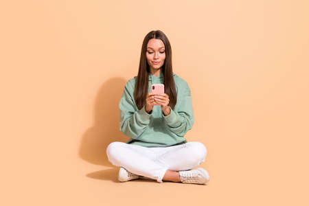 Portrait of attractive cheery addicted girl sitting using gadget app 5g smm social network isolated...