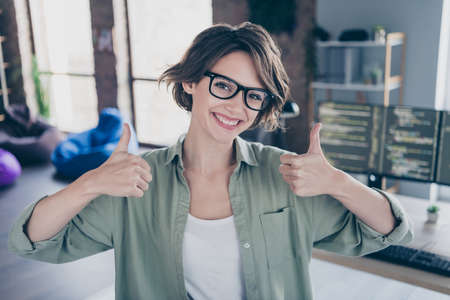 Portrait of smiling server optimization expert two hands show thumb up approve office room indoorsの写真素材