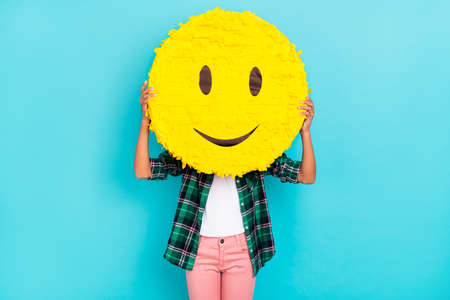 Photo of anonymous incognito lady hold emoji smile cover face wear plaid shirt isolated teal color backgroundの写真素材