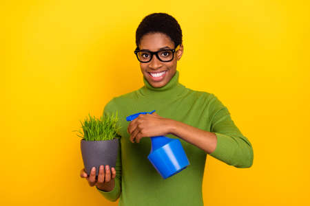 Photo of cute shiny short hair lady dressed green turtleneck water grass isolated yellow color backgroundの写真素材