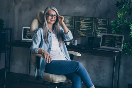Photo of confident pensioner retired lady ceo company owner ready security improve development sit chair in workspaceの写真素材
