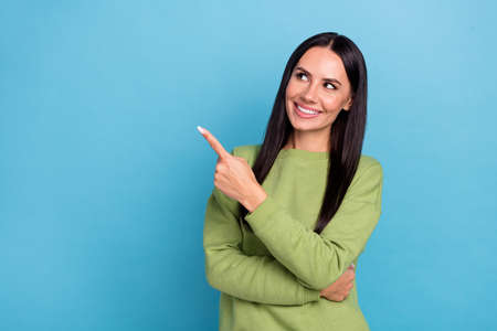 Photo of young adorable positive office worker lady promote ad look blank space isolated on blue color backgroundの写真素材