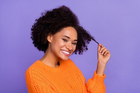 Portrait of attractive cheerful cute girl touching curls good mood isolated over bright purple violet color backgroundの写真素材