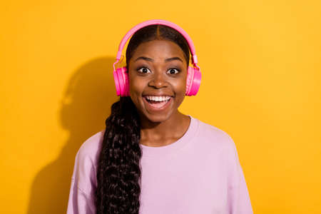 Photo of crazy astonished girl enjoy playlist melody look camera isolated on yellow color backgroundの写真素材