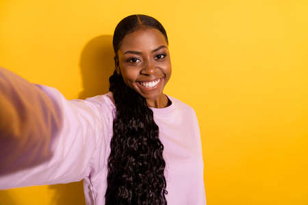 Photo of cheerful friendly lady make selfie recording video toothy smile isolated on yellow color backgroundの写真素材