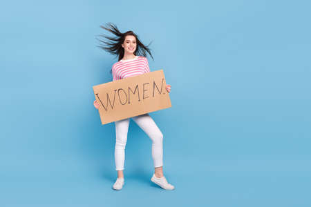 Full size portrait of positive pretty lady hold presenting paper blank isolated on blue color backgroundの写真素材