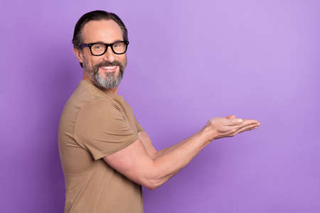 Profile side photo of good mood man promoting cool product make charity donation isolated on violet color backgroundの写真素材