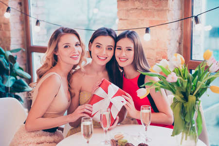Photo of lovely ladies chilling sit table in modern cafe hold wish dream package enjoy festive event wear dressesの写真素材