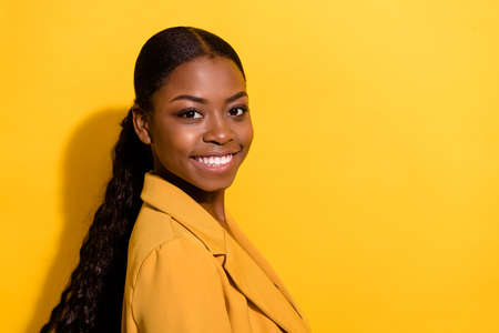 Profile side view portrait of attractive cheerful wavy-haired girl expert copy space isolated on bright yellow color backgroundの写真素材
