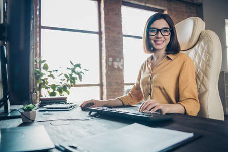 Portrait of attractive cheerful skilled girl company leader partner writing email at workplace workstation indoorsの写真素材