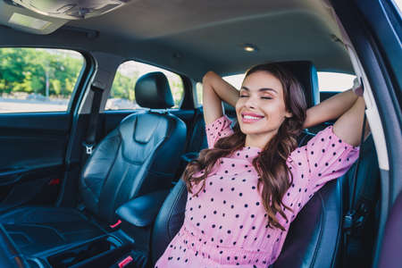 Photo of young cheerful attractive girl sit car hands behind head rest drowse sleepy vacation...