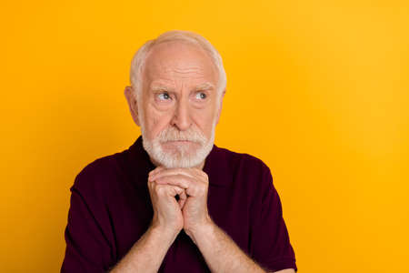 Photo of mature man hands touch chin think look empty space minded isolated over yellow color backgroundの写真素材