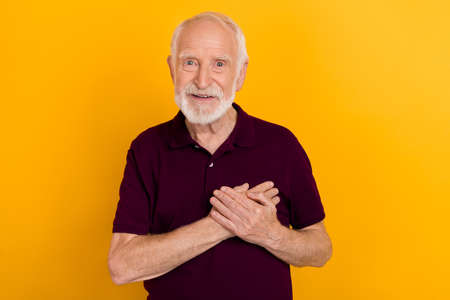 Photo of funny elder man hold palms wear blueberry t-shirt isolated on yellow color backgroundの写真素材