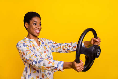 Profile photo of positive person hold wheel look empty space isolated on yellow color background