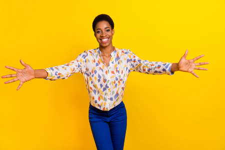 Portrait of cheerful satisfied person opened arms welcome come here isolated on yellow color...