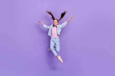 Photo of cute adorable small schoolgirl dressed jeans shirt jumping high falling down isolated...