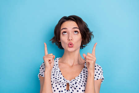 Photo of impressed pretty lady plump lips look direct fingers empty space promotion isolated on blue...