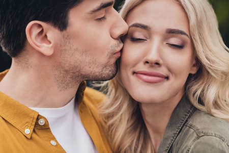 Cropped view portrait of attractive sweet careful amorous couple bonding kissing on fresh air...