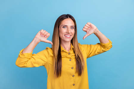 Photo of cute mature brown hairdo lady index herself wear yellow shirt isolated on blue color...
