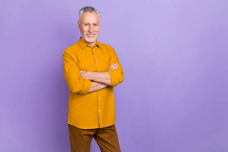 Photo of hr elder white hairdo man crossed palms wear yellow shirt isolated on purple color backgroundの写真素材