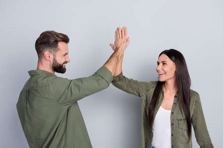 Portrait of attractive cheerful couple best successful team giving five isolated over grey pastel color backgroundの写真素材