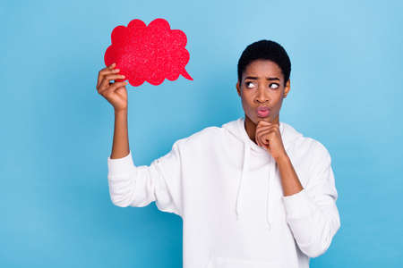 Photo of young girl guy hmm thoughtful minded hmm creative look paper poster isolated over blue color backgroundの写真素材