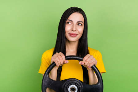 Portrait of pretty positive lady hold wheel look interested empty space isolated on green color...