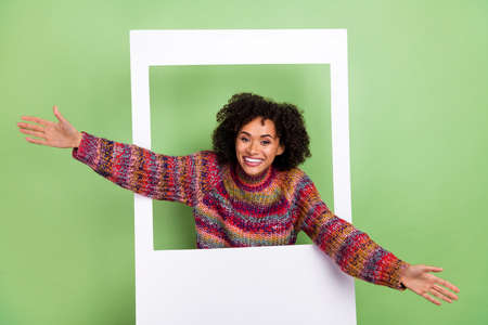 Photo of hooray young wavy hairdo lady in frame wear red sweater isolated on green color backgroundの写真素材