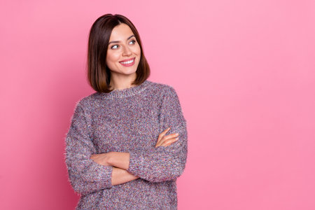 Portrait of attractive cheerful brown-haired minded girl folded arms deciding copy space isolated over pink pastel color backgroundの写真素材