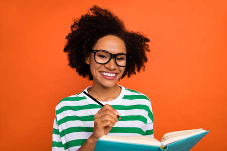 Portrait of beautiful trendy brainy cheerful wavy-haired girl writing plan list planner isolated on...