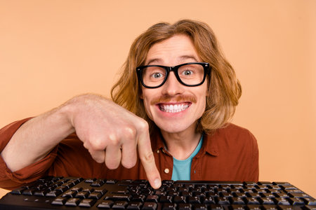 Portrait of handsome trendy cheery red-haired guy writing text learn remote isolated over beige pastel color backgroundの写真素材