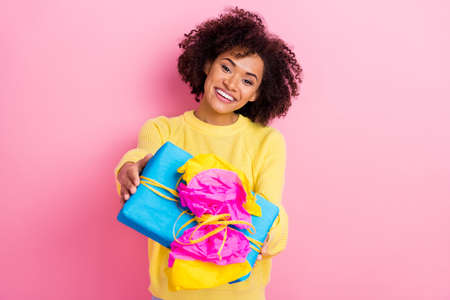 Photo of young cheerful pretty girl event festive give present box isolated over pink color backgroundの写真素材
