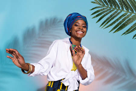 Photo of zulu cute lady in national summer accessories dance tribe green leaves isolated on shade colored backgroundの写真素材