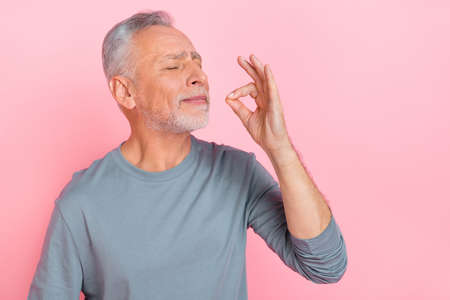 Photo of sweet dreamy retired man wear grey shirt trying tasty dish isolated pink color background