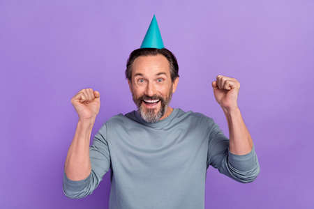 Photo of mature man rejoice luck triumph fists hands awesome glad isolated over violet color backgroundの写真素材