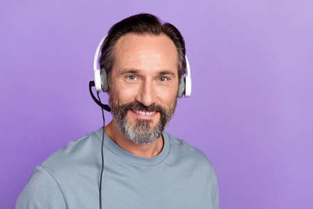 Photo of mature cheerful man expert wear headset agent manager isolated over violet color backgroundの写真素材