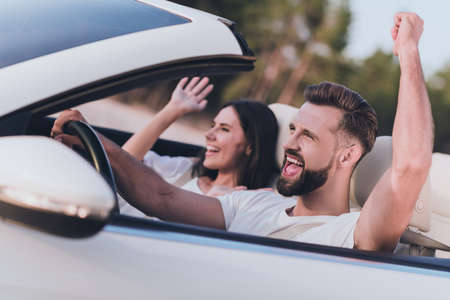 Photo of adorable lucky husband wife wear casual clothes riding cabriolet rising fist celebrating...