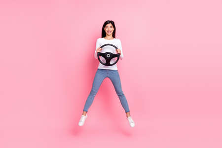 Full size photo of cool millennial brunette lady jump drive wear shirt jeans footwear isolated on...