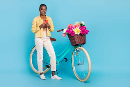 Full length body size view of beautiful trendy cheery girl riding bike using device chat isolated on...