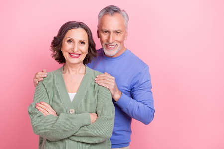 Portrait of two idyllic positive people hug folded hands beaming smile isolated on pink color...
