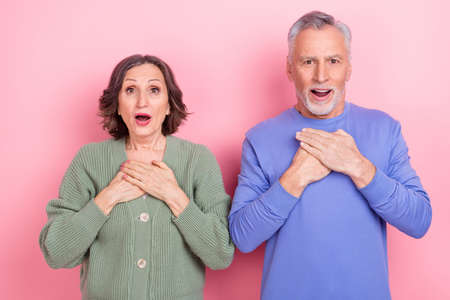 Photo of two funky impressed partners arms chest open mouth stare speechless isolated on pink color backgroundの写真素材