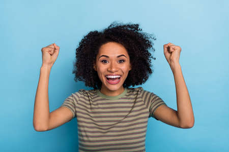 Photo of delighted lady rejoicing winning fan champion fist up isolated on blue color background