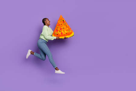 Full size profile side photo of positive overjoyed young lady excited to see huge pizza isolated on violet color backgroundの写真素材