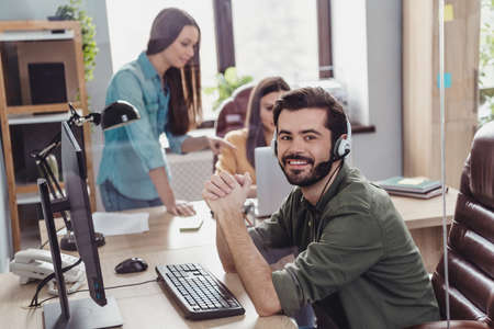 Photo of three employee operator sitting chair communicate speak clients office building indoors
