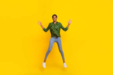 Photo of funky excited androgynous person dressed smart casual jumping high isolated yellow color...
