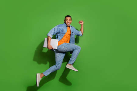 Full body image of energetic active young man running to office deadline time isolated on green...